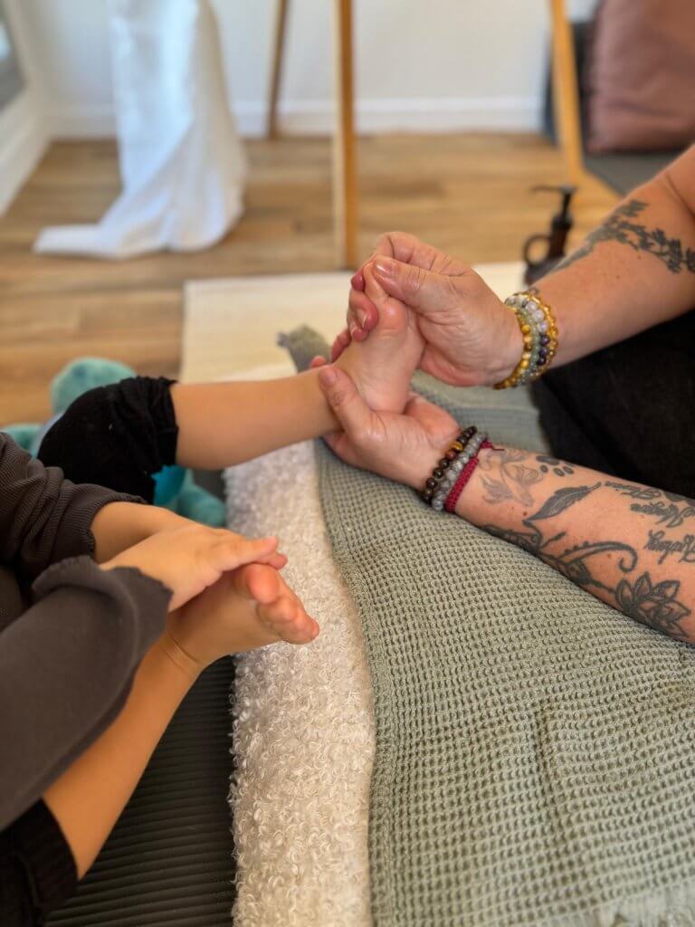 Photo d'une séance de réflexologie plantaire pour enfant/bébé.