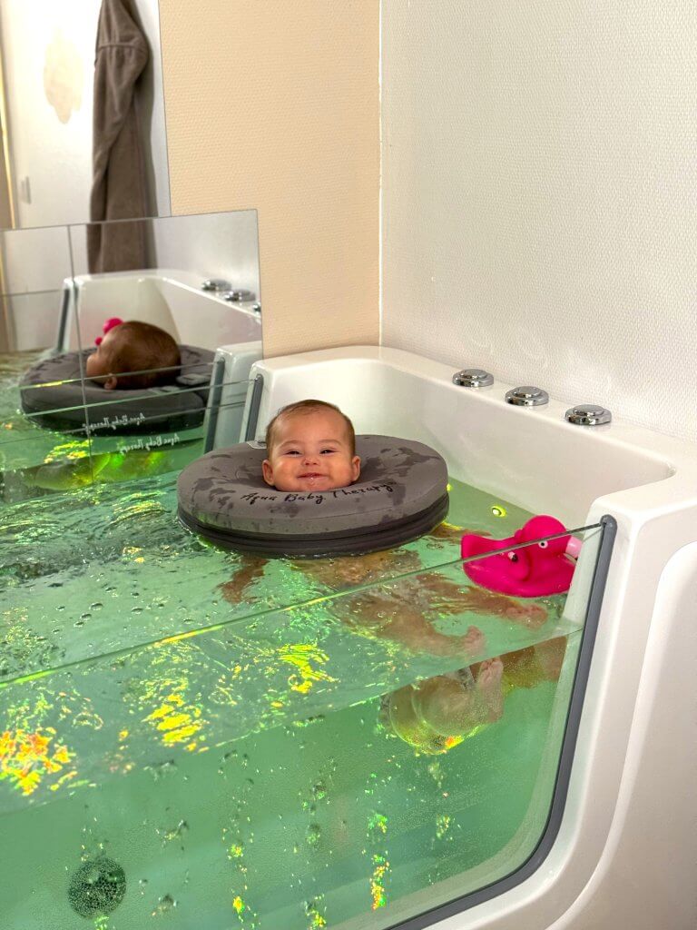 photo d'un bébé qui fait une séance de hydrothérapie au cocon d'alya baby spa a artix
